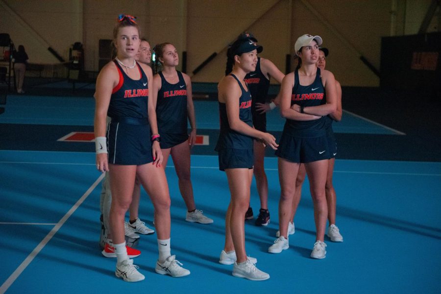 The+Illinois+womens+tennis+team+huddle+on+the+court+as+they+watch+their+intro+video+before+their+matches+against+Rutgers+on+March+27.+The+Illini+will+begin+their+season+this+weekend+for+the+Wahoowa+Invite+in+Virginia.+