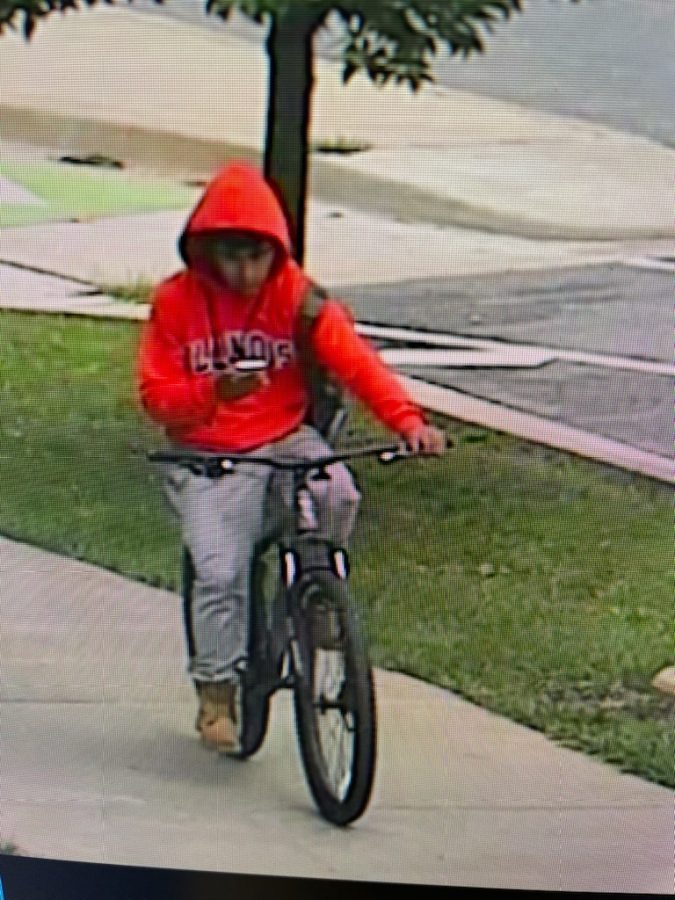 The suspect rides a bike near Wright Street on Monday. 