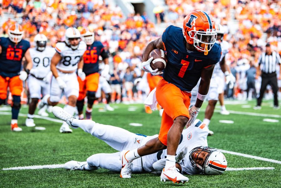 Sophomore wide receiver Isaiah Williams stiff arms Virginia defender to ground. Illinois dominated Virginia in blowout fashion, 24-3.