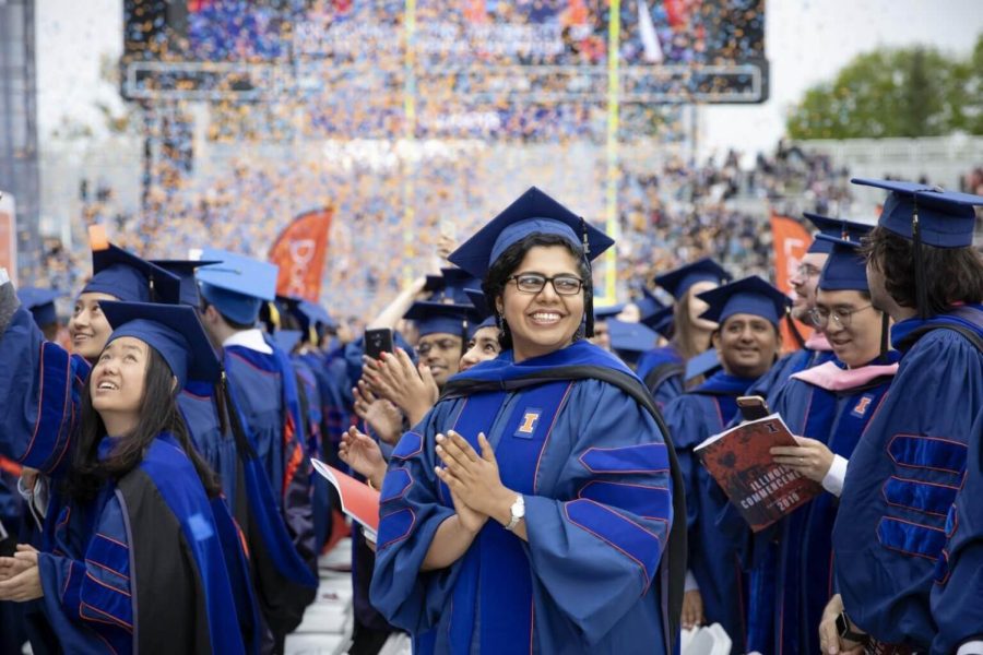 An I-MMÁS program student celebrates during the end of the 2019 graduation commencement ceremony, during the early development of the program. I-MMÁS program leaders speak on the collaboration and effects that the program has within the University of Illinois System.