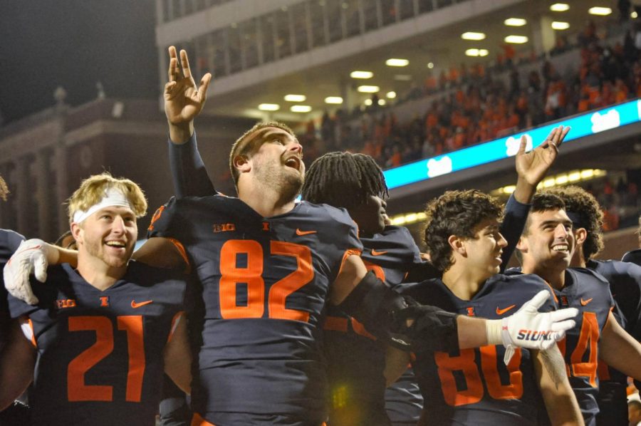 Senior tight end Luke Ford and other Illinois football players sing “Hail to the Orange” with fans as they celebrate their win against Iowa on Saturday.