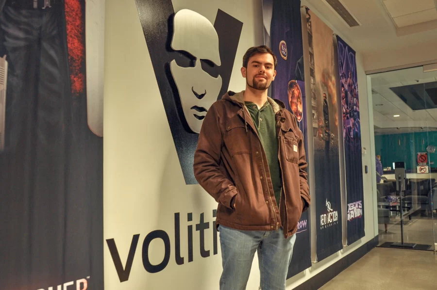 Trevor Burke poses at the entrance of Volition’s lobby in downtown Champaign on Oct. 18. Burke works as a sound designer for the video game company. 
