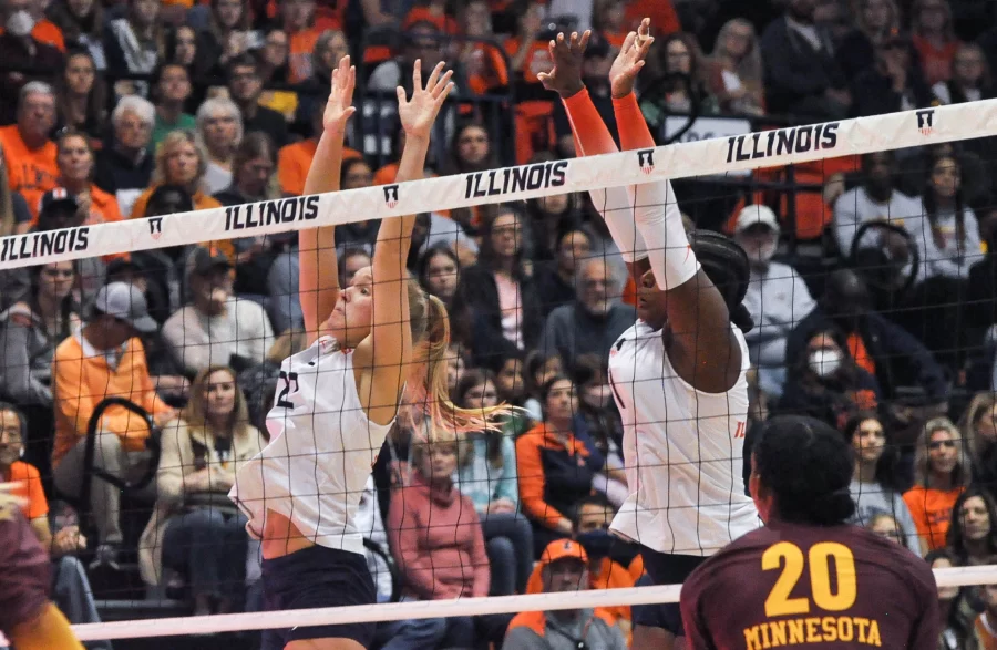 Redshirt freshman Brooke Mosher (22) and senior middle blocker Kennedy Collins (1) go to block Minnesotas ball during their match up on Sunday. 
