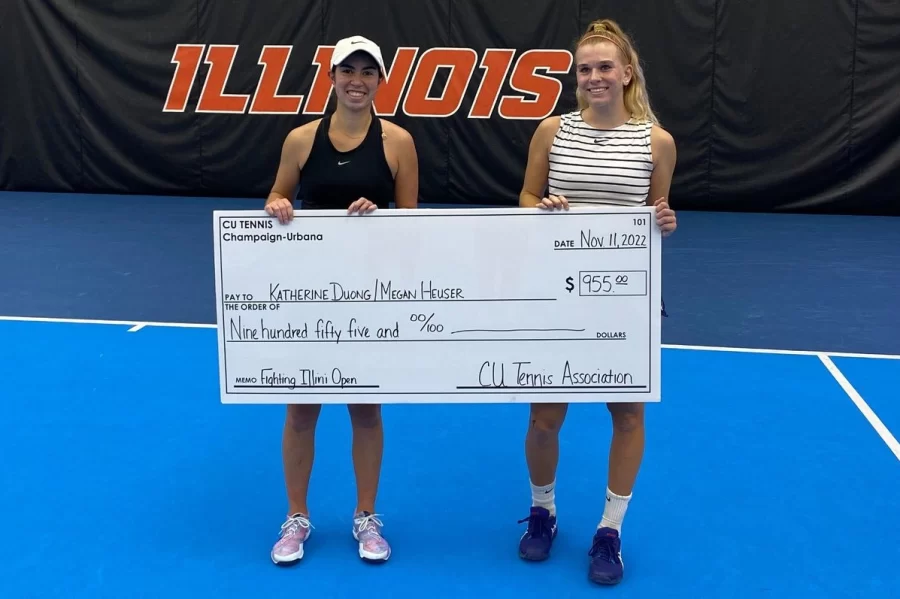 Junior Kate Duong and sophomore Megan Heuser receive their doubles championship check during yesterdays event at Atkins Tennis Center. During todays game, Duong and Heuser defeated their opponents in two sets which led the duo to earn their first professional doubles championship. 