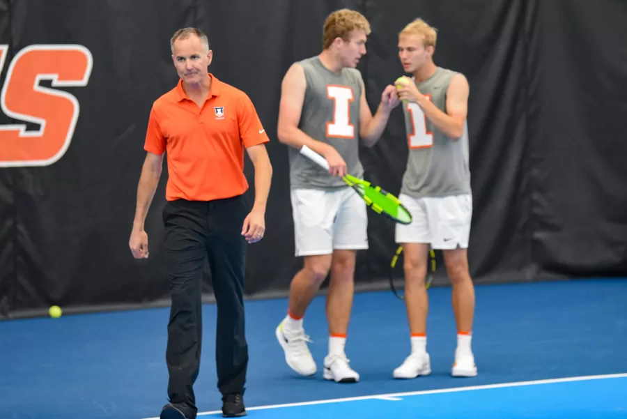 Mens tennis head coach Brad Dancer walks away after conferring with current sophomores Gabrielius Guzauskas and Karlis Ozolins at a match against Purdue on April 24, 2022. Dancer said that the season started off strong, but the teams next steps will test their toughness.