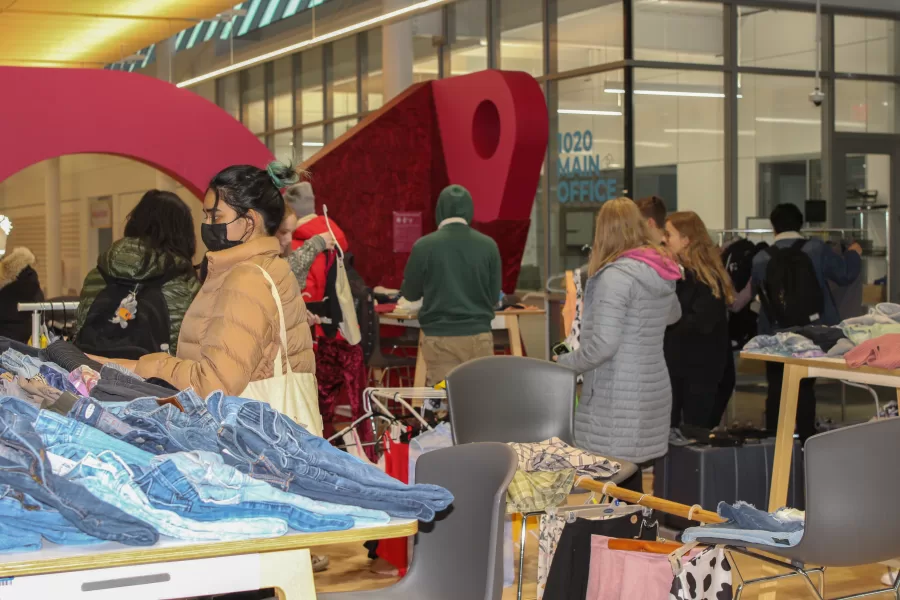 Students shop around at the pop-up thrift shop held by Phi Delta Epsilon at the Siebel Center for Design on Thursday. The shop will also be open for thrifters on Saturday from 12:00 p.m. to 4:00 p.m.