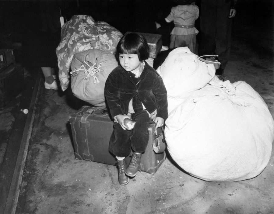 Yuki Okinaga Hayakawa Llewellyn sits on a suitcase at Union Station in Los Angeles, waiting for the train taking her and her mother to the Manzanar War Relocation Center. She later worked at the University of Illinois for many years, including as Assistant Dean of Students and Director of Registered Student Organizations.