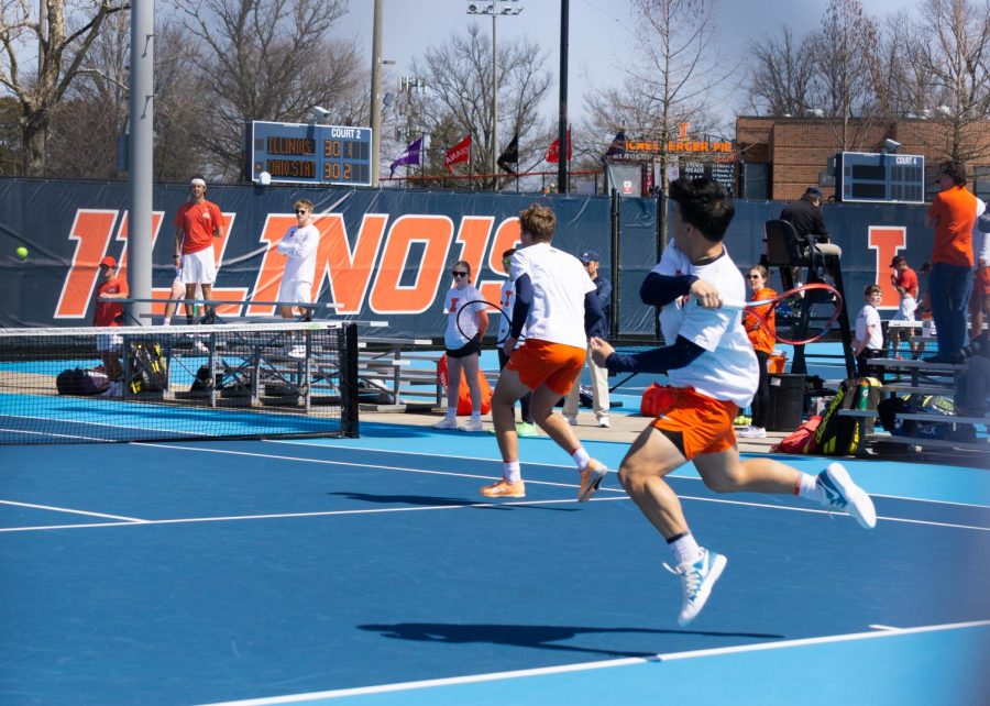 Hunter Heck and Karlis Ozolins playing Andrew Lutschaunig and James Trotter in a doubles match. Heck returns the ball with a forehand swing. 
Heck and sophomore Karlis Ozolins were defeated by Northwestern on Saturday, making this the Illinis first double loss this season.