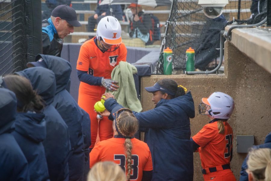 The Illini softball team wipes their softballs during a rainy game against Rutgers on Mar. 24. 
The Illini traveled to Michigan where they took on an unfortunate loss. 