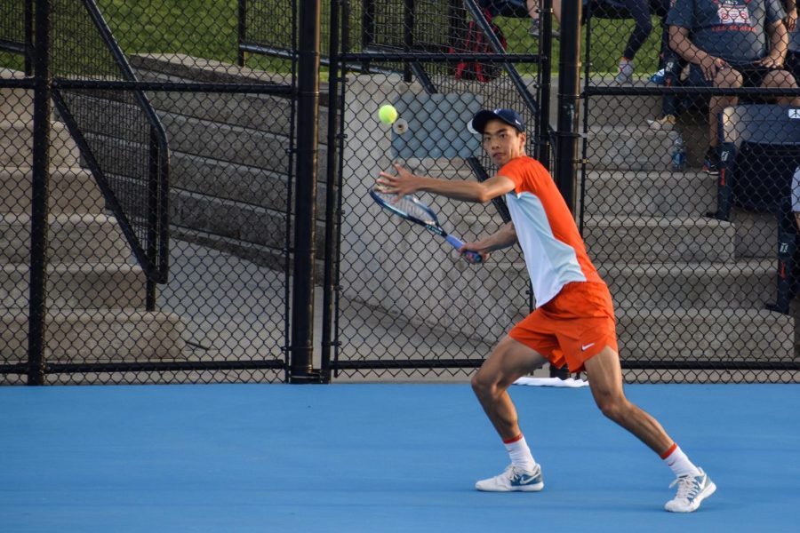 Freshman Kenta Miyoshi starts a serve against Michael Minasyan from Wisconsin in tennis singles on April 14.