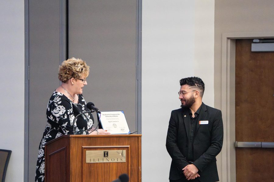 System Trustee Tami Craig Schilling presents Student Trustee Rafael Camacho Jr. with certificate of achievement at board of trustees meeting on Thursday