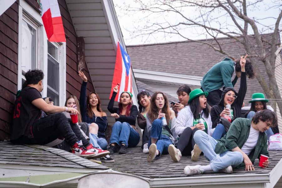 Students drink on the roof of a house during Unofficial 2023. 