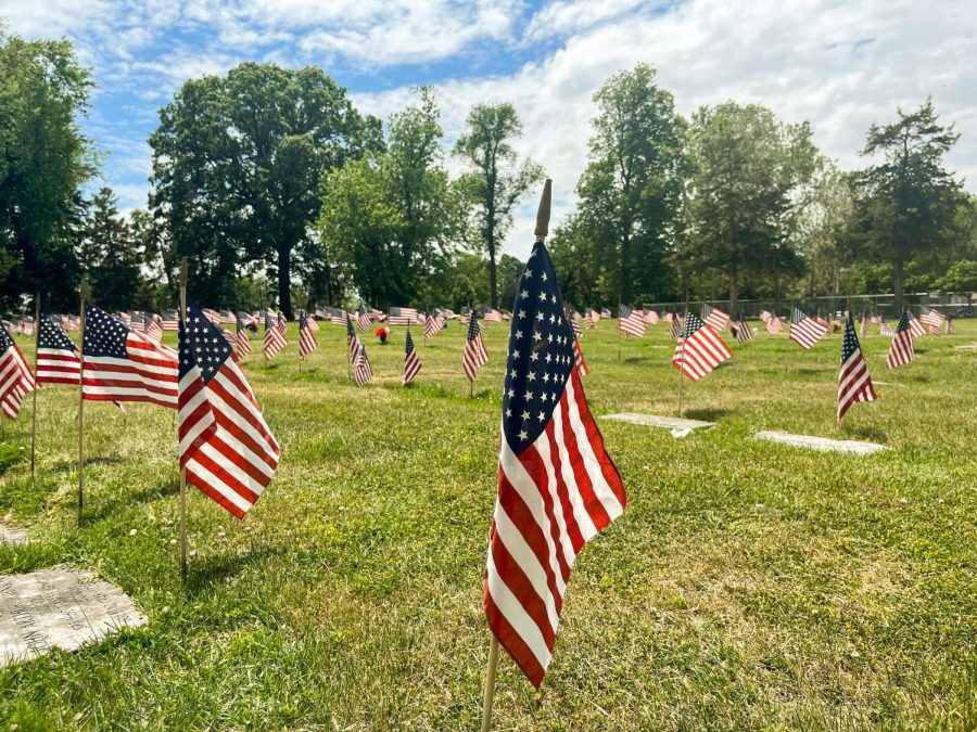 American flags placed at headstones of US military veterans at Mt. Hope Cemetery in Urbana.