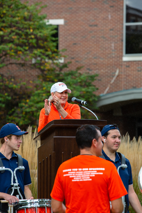 The CU community and Illini family come to the Alice Campbell Alumni Center to watch the fountain kick off the homecoming week as Jen Dillavou, the president of the University of Illinois Alumni Association gives a speech during a rainy day on Oct. 2, 2021.