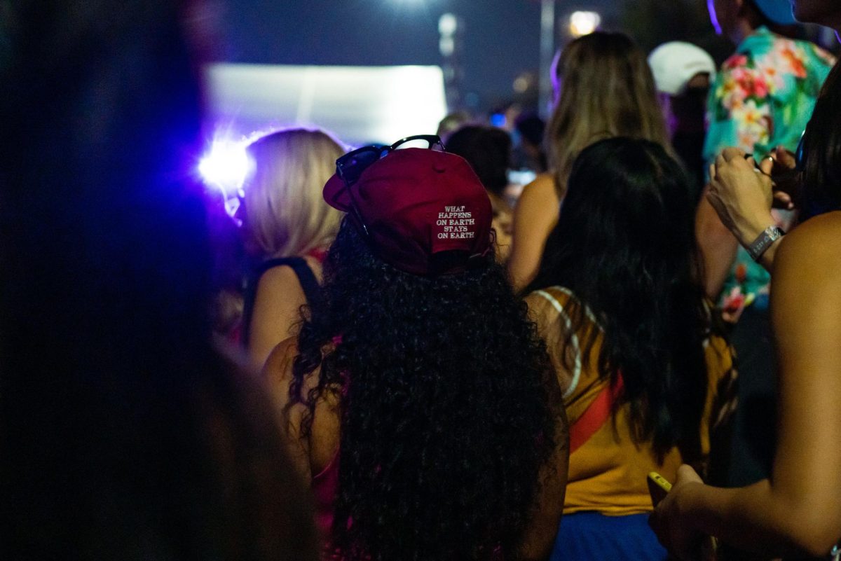 Kendrick Lamar attendee watches T-Mobile set performance wearing Kendrick Lamar What happens on earth stays on earth merch amongst crowd on Friday night. 