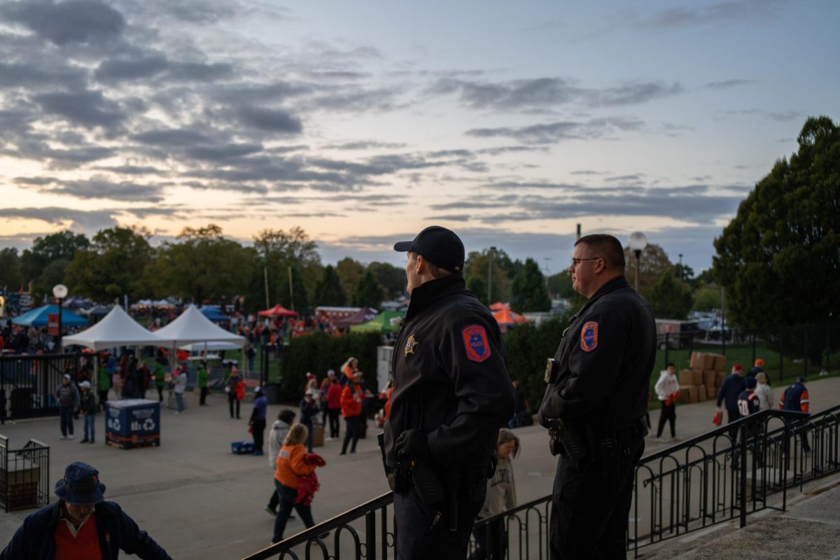 UIPD police officers look out into a crowd of tailgaters before the football game on Friday.
