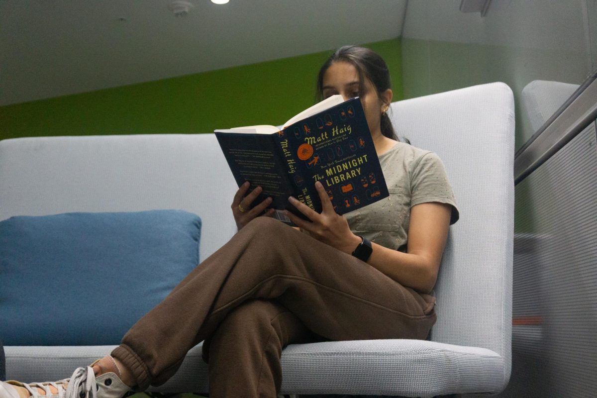 Mukta Phatak, junior in college of FAA and LAS, reading The Midnight Library by Matt Haig. She is reading on the couches in the lower level of the Siebel Center for Design.

