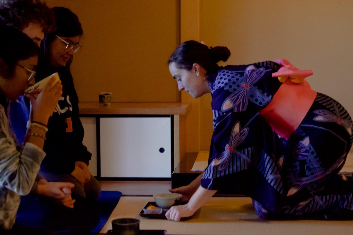 An intern at the Japan House serves tea during Homecoming matcha ceremony event on Friday. 