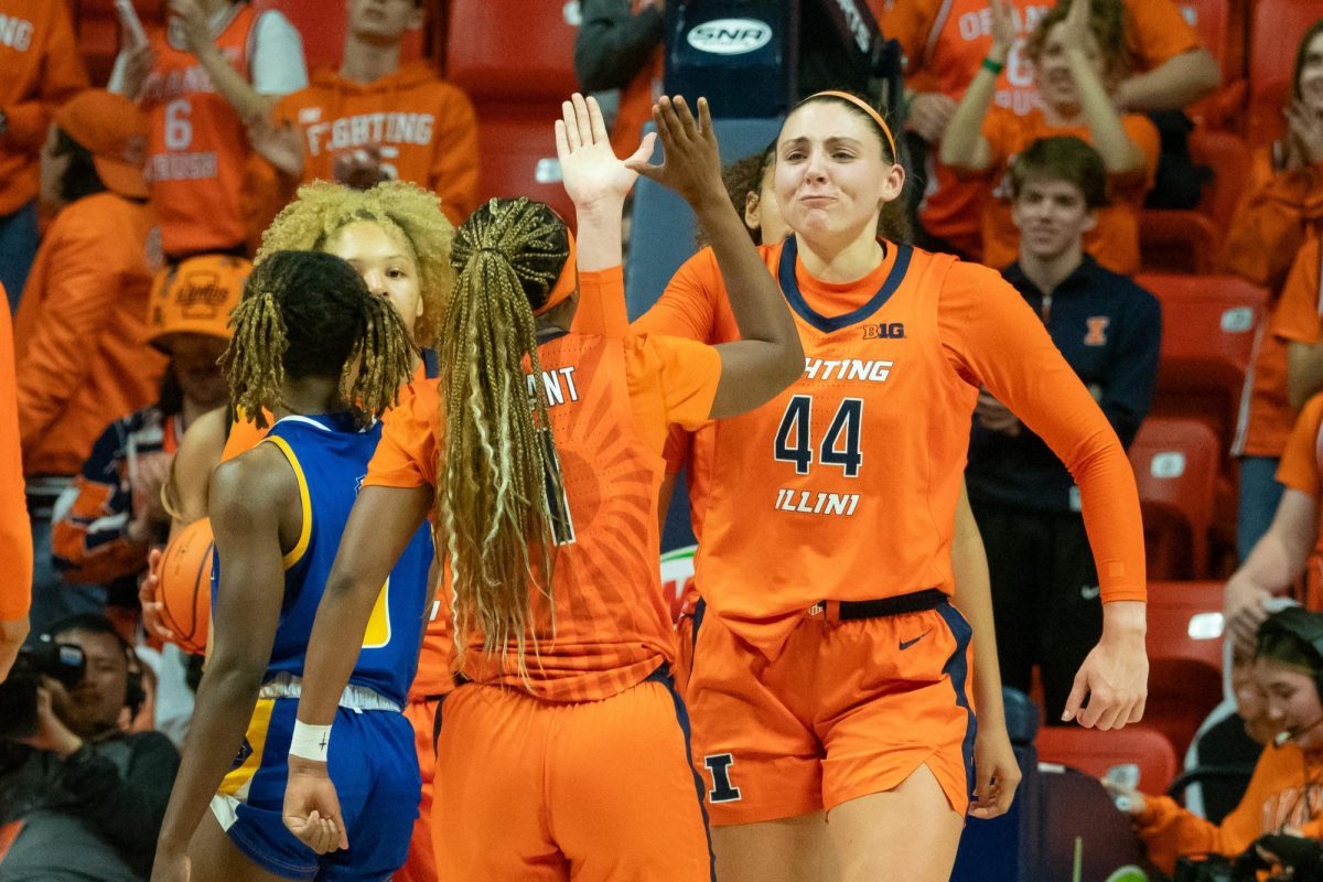Senior Kendall Bostic high fives senior teammate Genesis Bryant after Bostic drew a foul while making a layup. Bostic had a double-double for Illinois against the Morehead State.