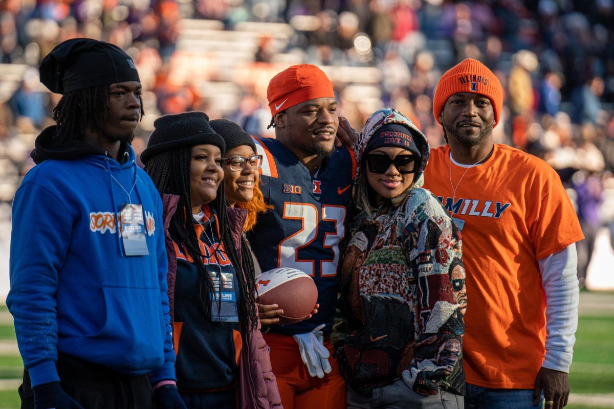 Junior running back #23 Reggie Love III gathers with his family before the game for a photo on Nov. 25. 