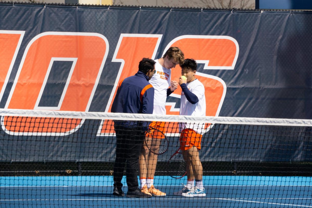 Volunteer+coach+Jayman+Jhattu+talks+to+Hunter+Heck+and+Karlis+Ozolins+in+between+plays.+They+all+huddle+to+discuss+strategy+during+the+doubles+match+against+Ohio+State+at+Atkins+Tennis+Center+on+Mar.+26.