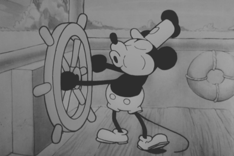 Mickey Mouse in 1928 cartoon short Steamboat Willie. 
The original Mickey Mouse will enter the public domain at the beginning of next year.