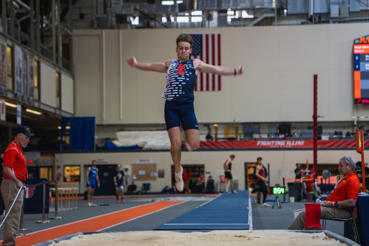 Senior Aiden Ouimet motions in mid-air during his long jump on Jan. 26.