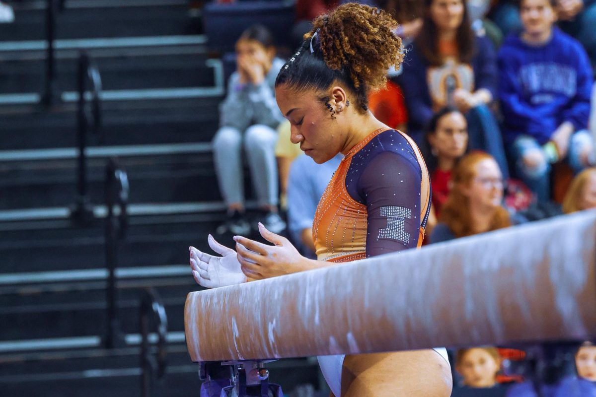 Graduate all-around Mia Townes prepares for her beam routine with chalk during the meet against Rutgers on Feb. 4.