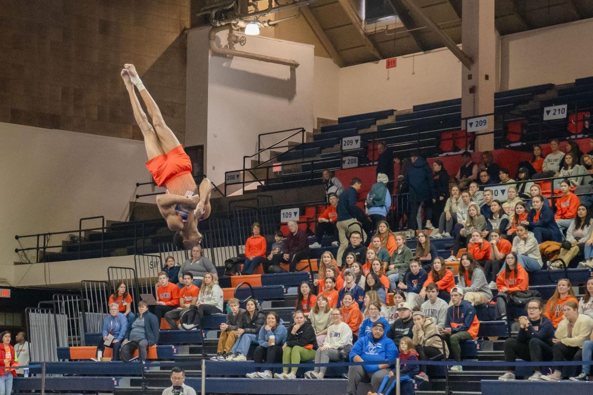 Junior all-around Amari Sewell flips in the air in front of an onlooking crowd during the meet against Michigan on Mar. 3.