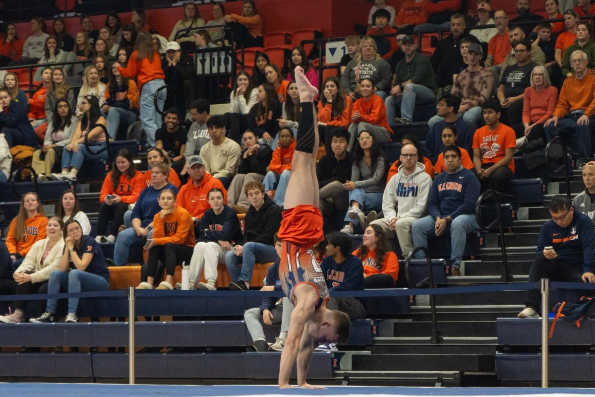 Graduate+student+Michael+Fletcher+holds+a+handstand+during+his+floor+routine+during+the+meet+with+Michigan+on+Feb.+3.+