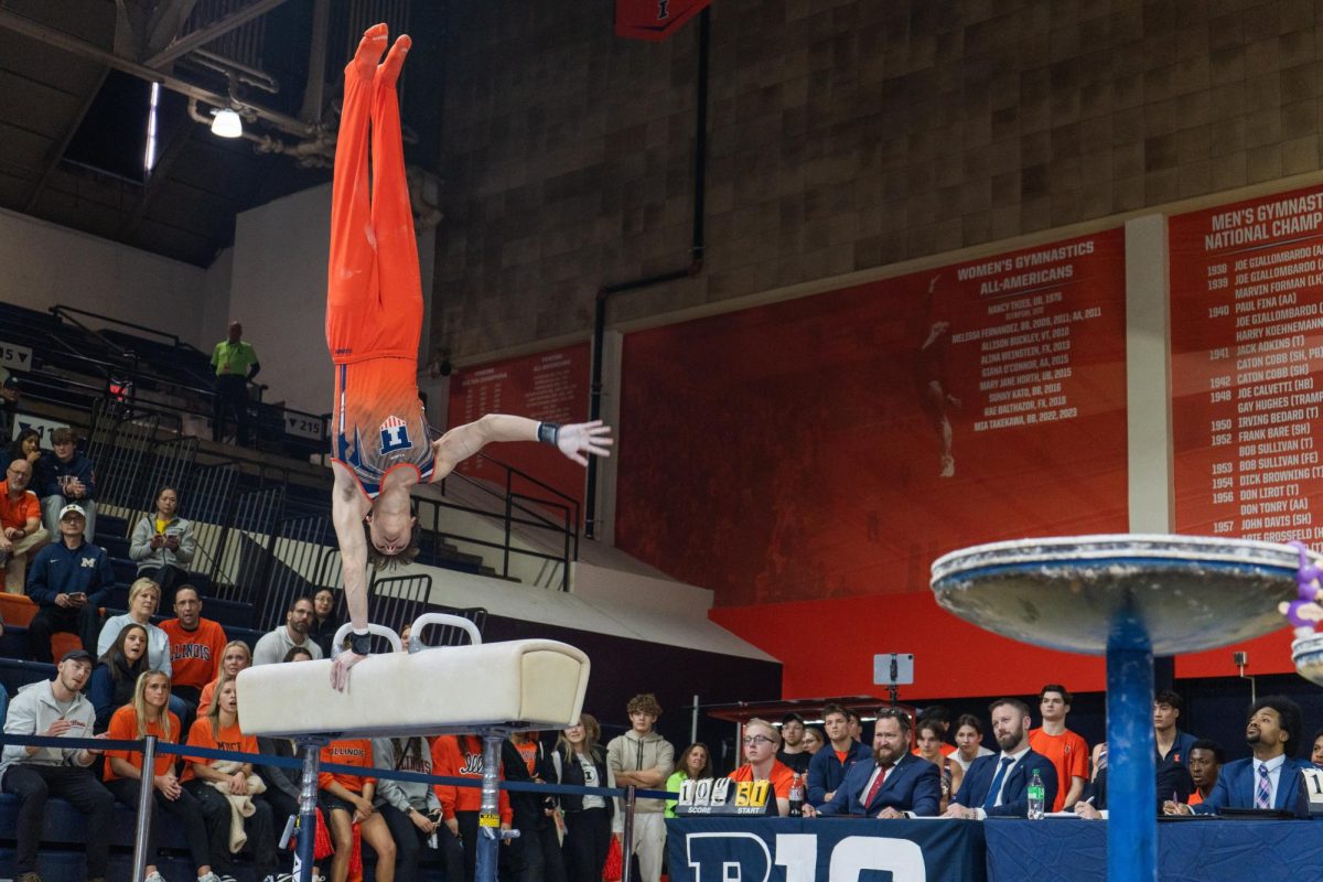 Junior Max Farkhadau holds a one-handed handstand during his pommel horse routine against Michigan on Feb. 3. 