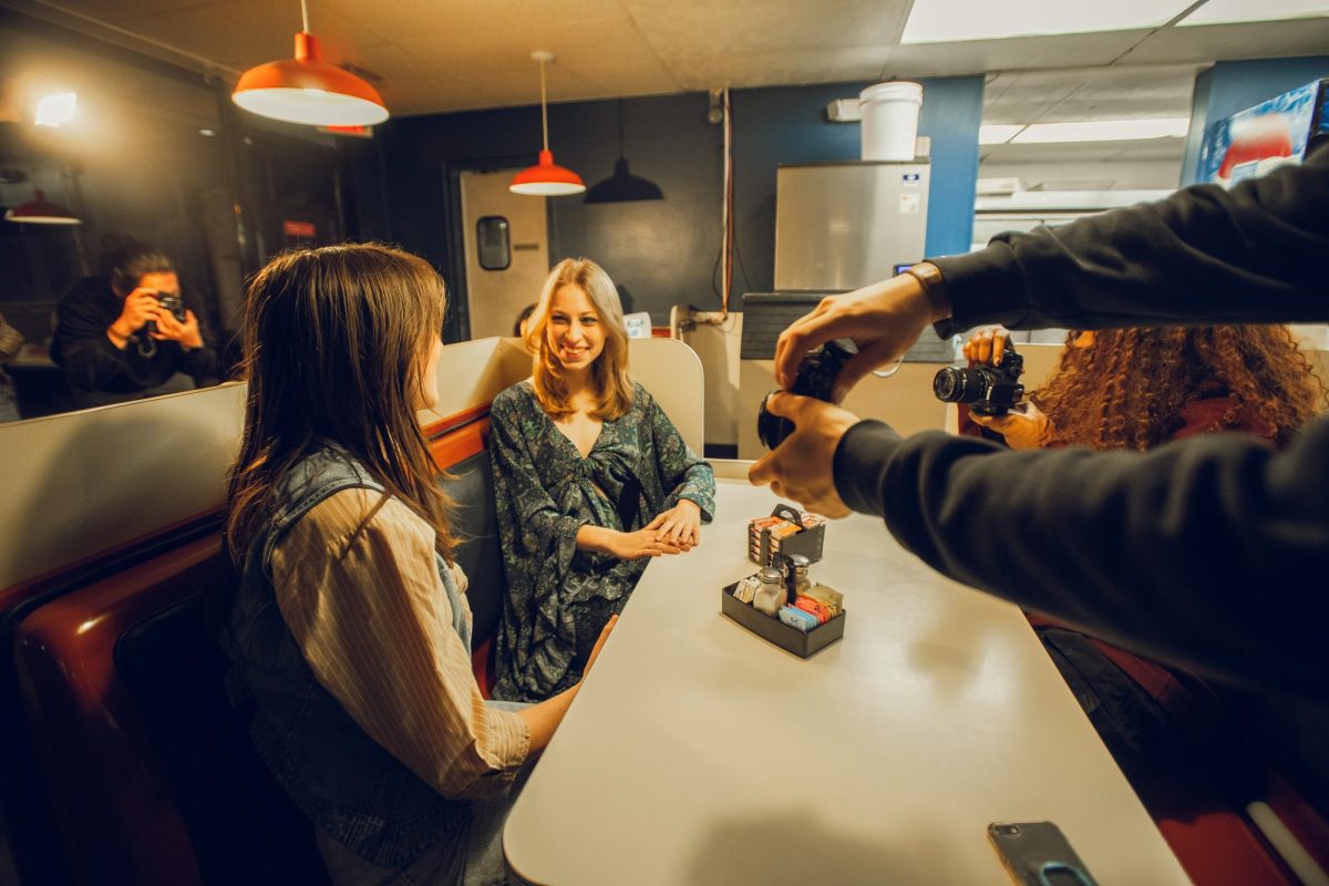 Members of BLNKD, a portrait photography and modeling RSO on campus, participate in a shoot at Merry Ann’s Diner at night.