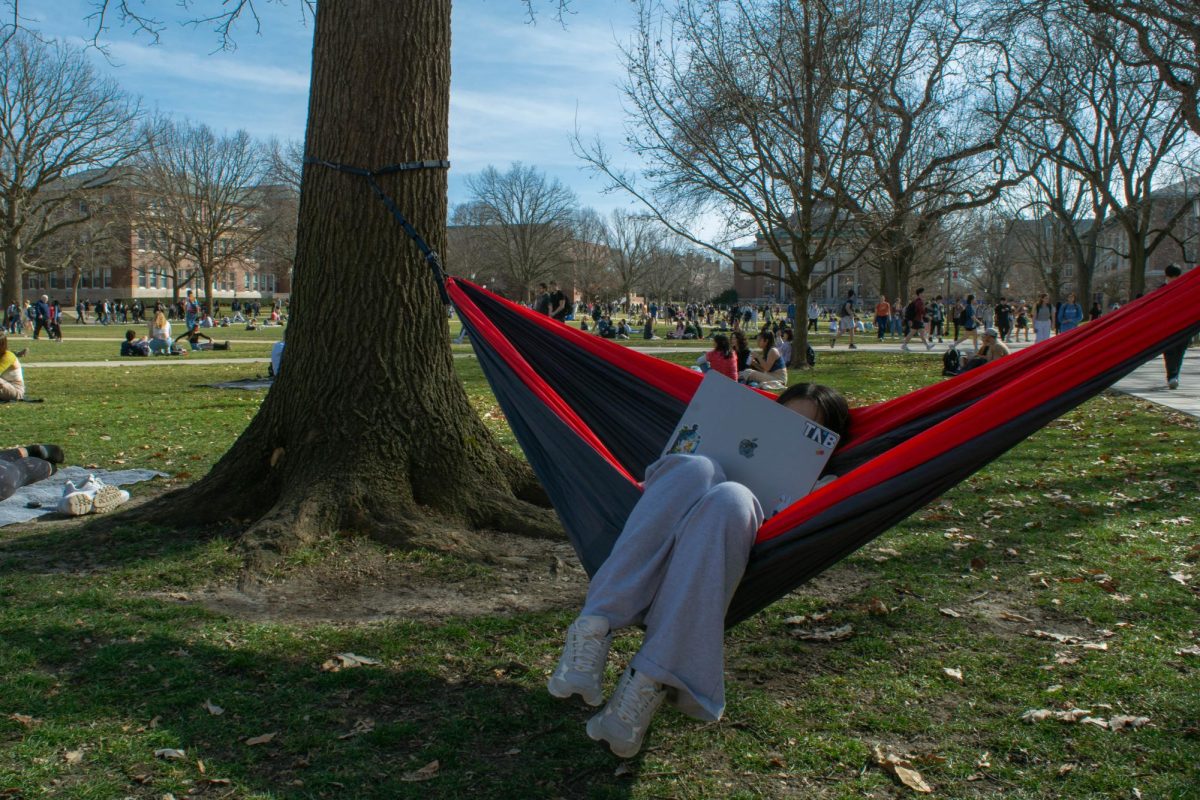 Janice Mei, sophomore in Engineering, does homework in a hammock on the Main Quad.