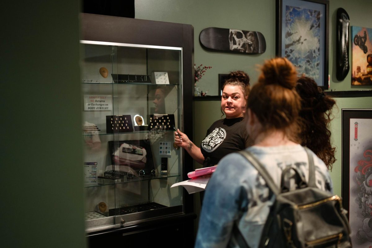 Customers of look at piercing options at No Regrets in downtown Champaign on March 2.