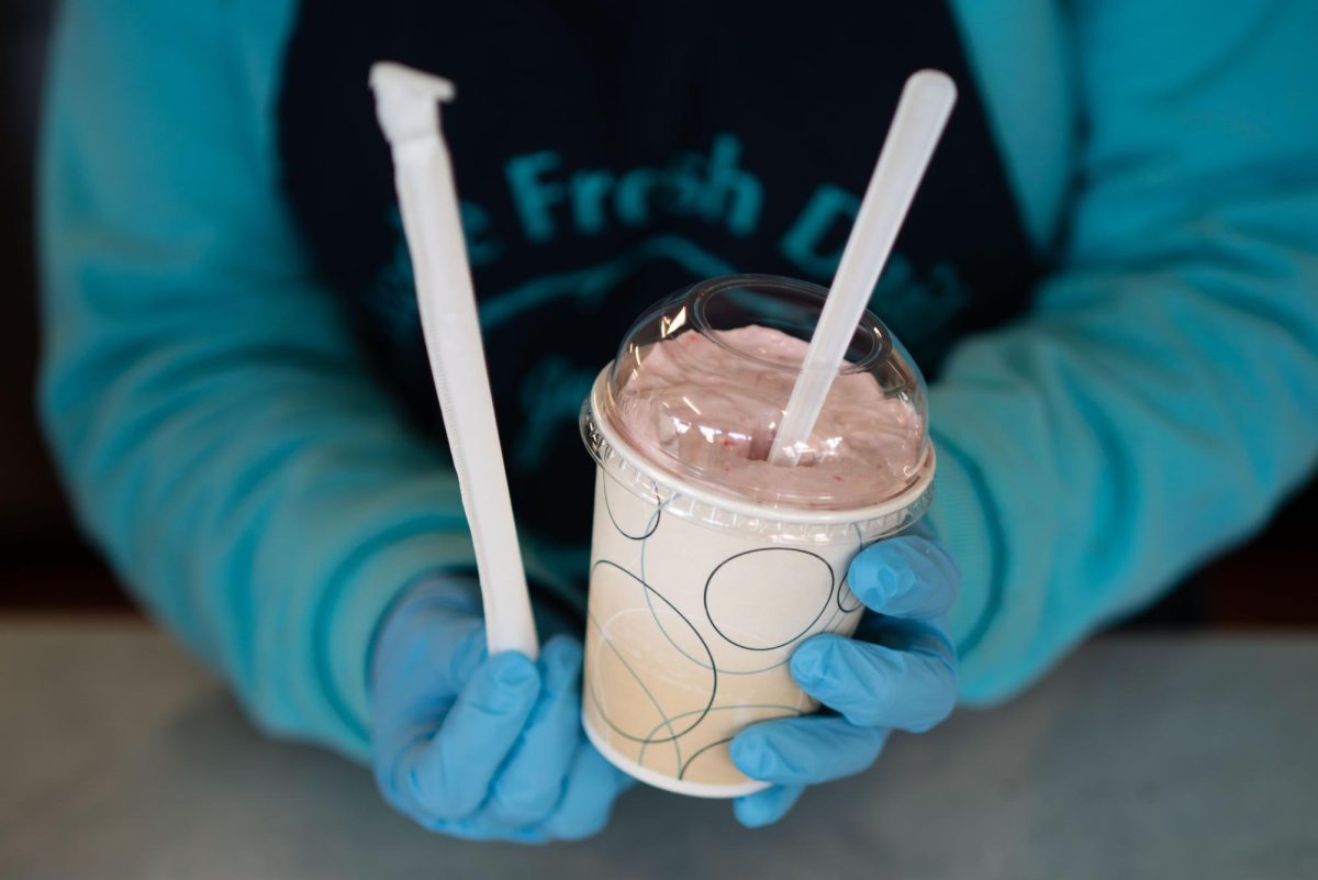 A Jarling’s Custard Cup worker hands a strawberry milkshake to customers in the afternoon on March 23. The shop is located at 309 W. Kirby Ave.