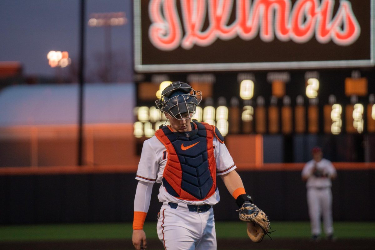 Junior catcher #17 Camden Janik walking back to home plate as the Illini had a quick team talk at the pitchers mound during a game on March 26.