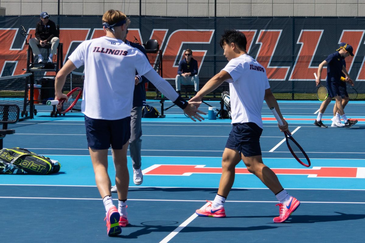 Senior Hunter Heck and Junior William Mroz high five between plays. Heck and Mroz lost to Michigans Gavin Young and Jacob Bickersteth in a doubles match on March 31.