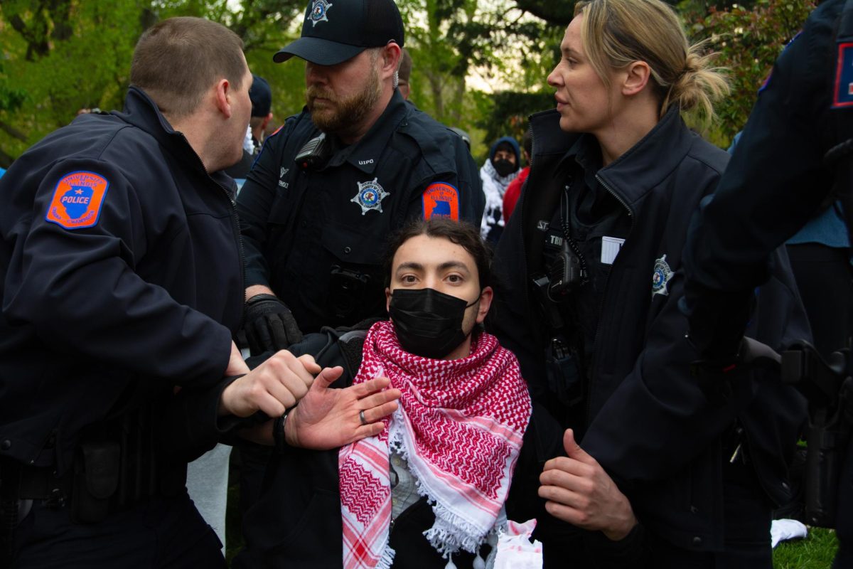 An attendee is taken into custody by UIPD during a Palestine encampment in front of Alma Mater on Friday morning.
