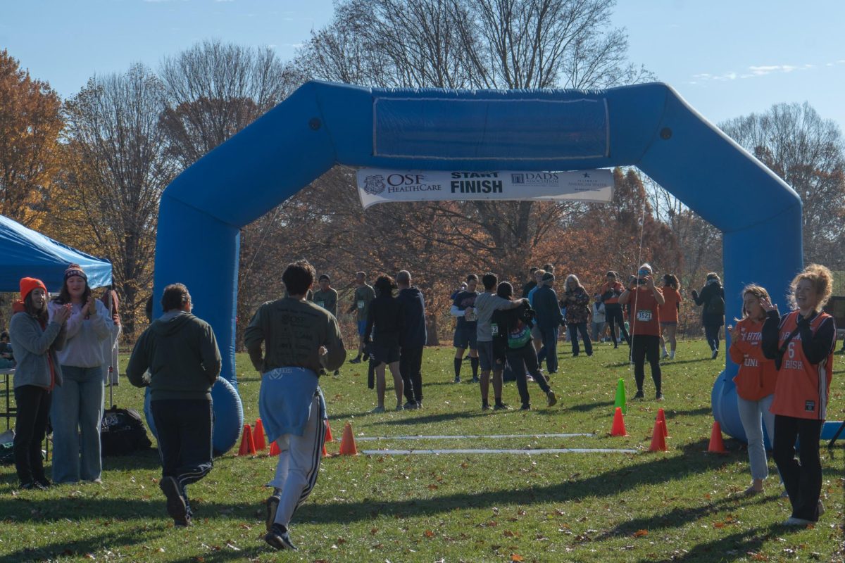 A dad and his son cross the finish line during the Illini Dads Weekend 5K run in the University of Illinois Arboretum on Nov. 12.