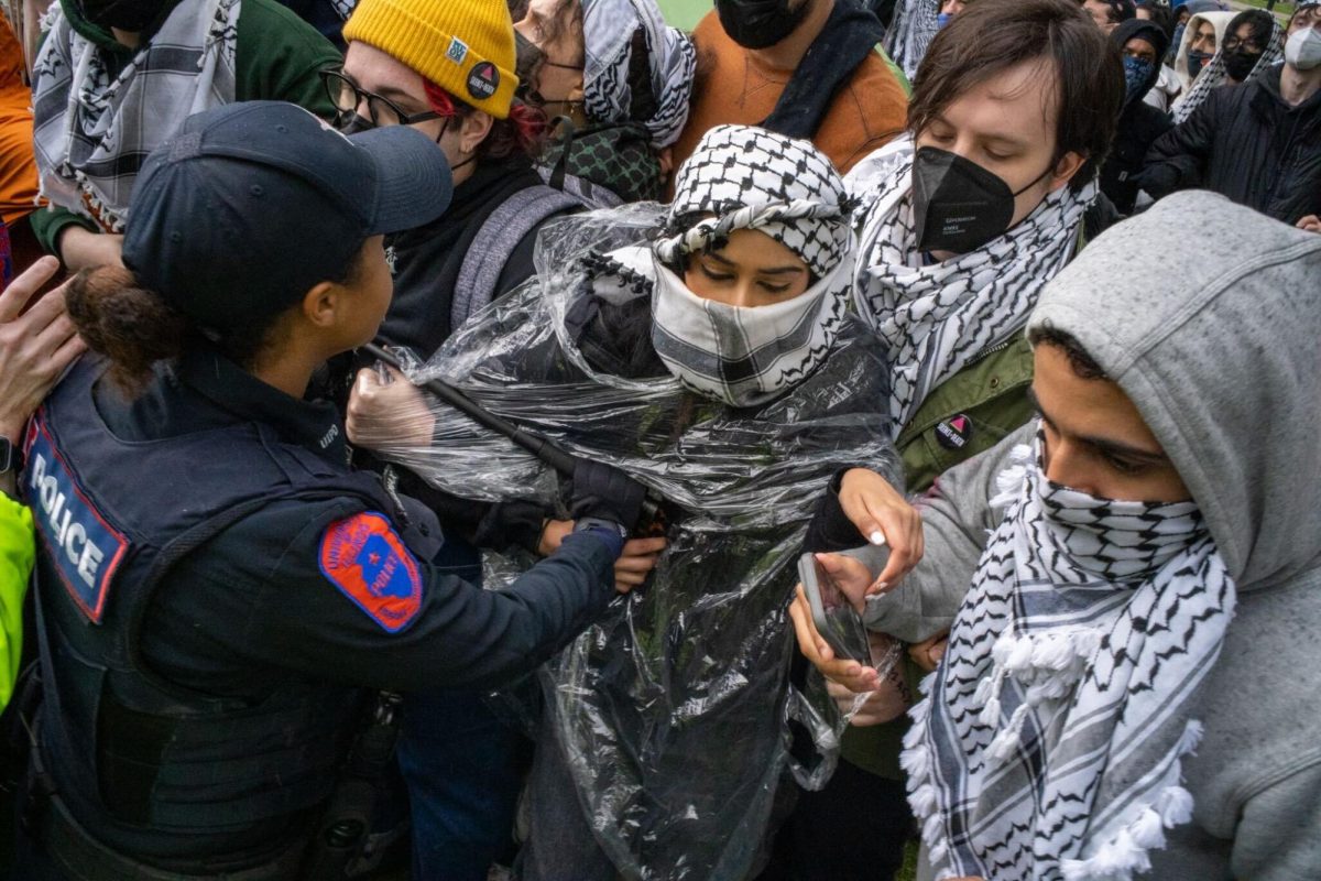 UIPD officers use force to enter the encampment as protesters link arms on April 26, 2024. The Champaign County State’s Attorney charged several protestors, including University students, with mob action. 