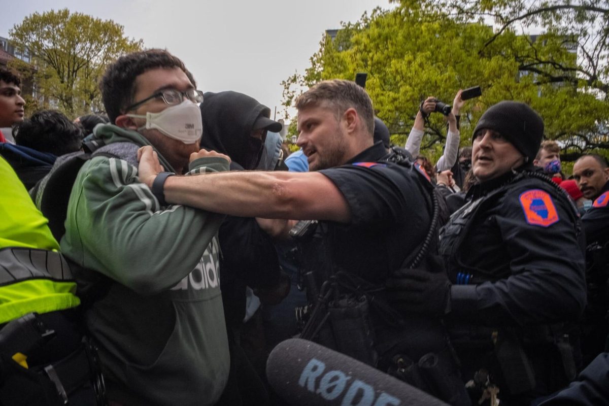 University Police use physical force to break through the barrier toward the encampment.