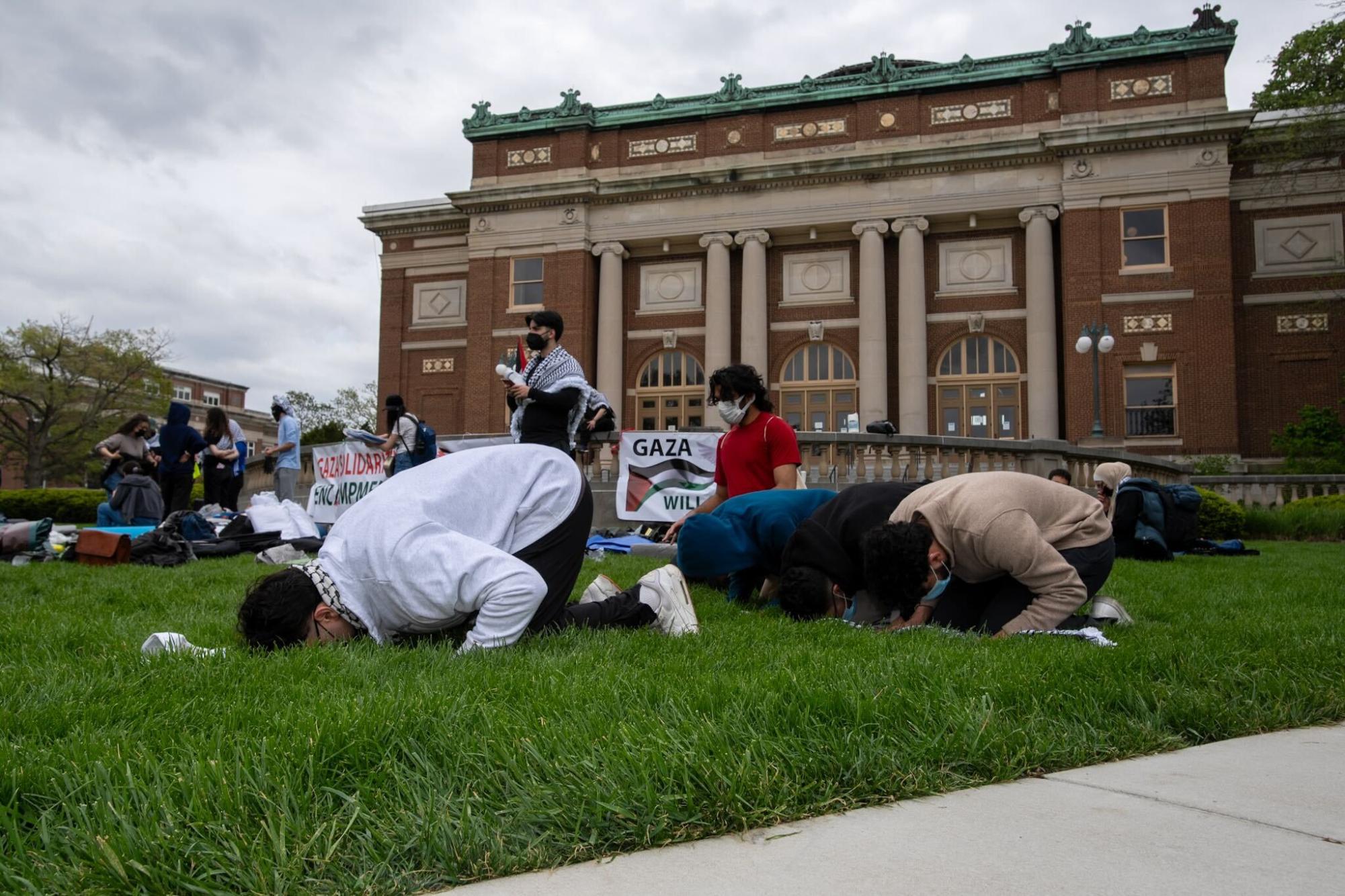 Demonstrators pray on the main quad.