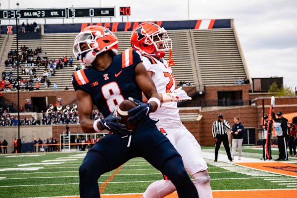 (Front) Sophomore wide receiver Malik Elzy scores the first touchdown during the first quarter of the Spring Game at Memorial Stadium on Saturday, with sophomore defensive back Ben Clawson closely behind.