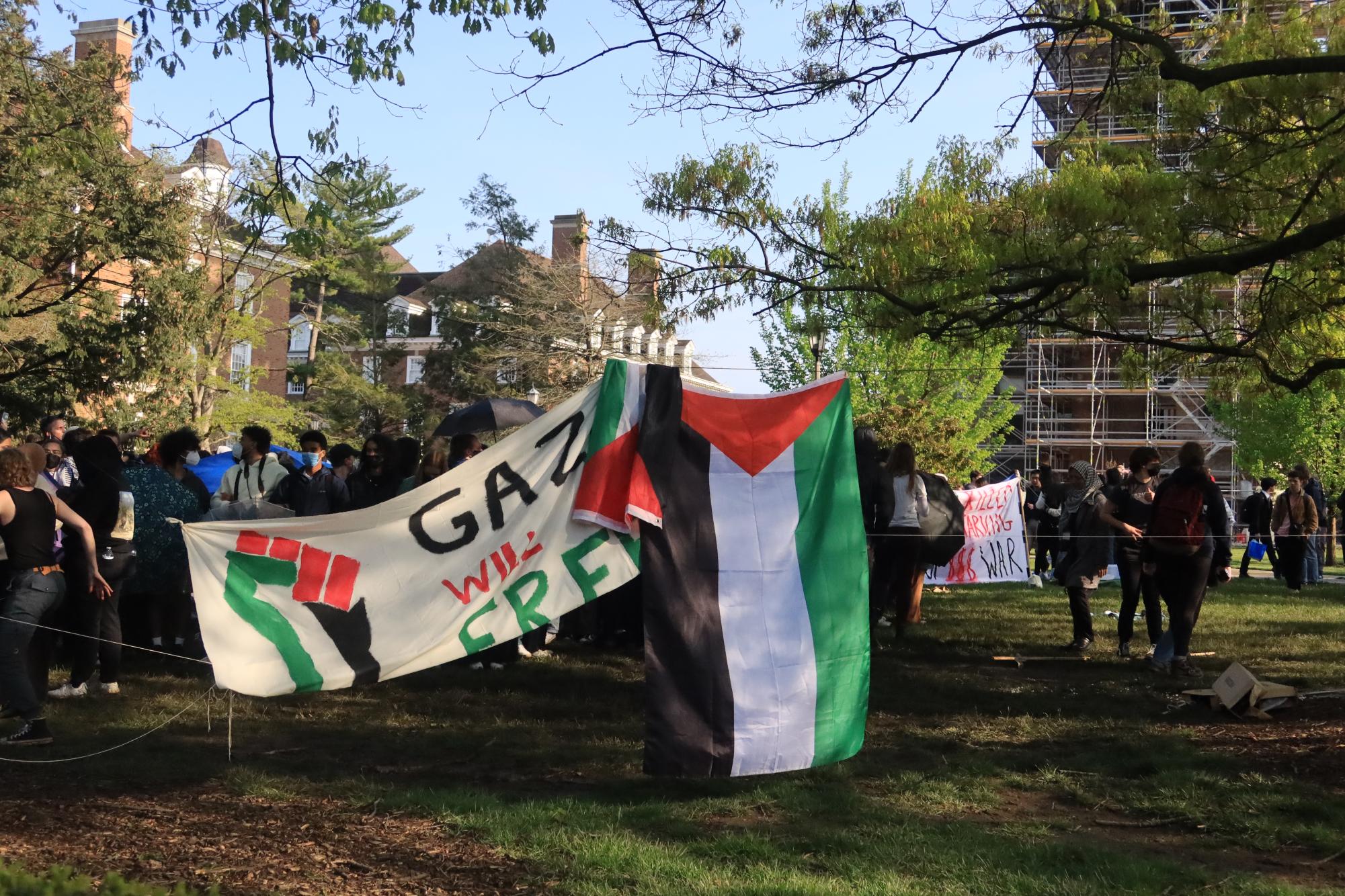 A flag of Palestine hangs from a tree on the north side of the demonstration.