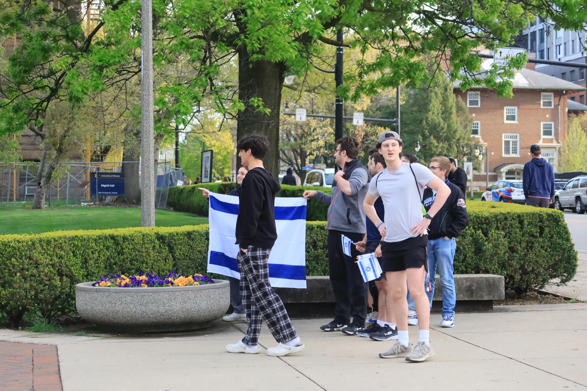Students stand near the encampment with the flag of Israel on Friday evening. 