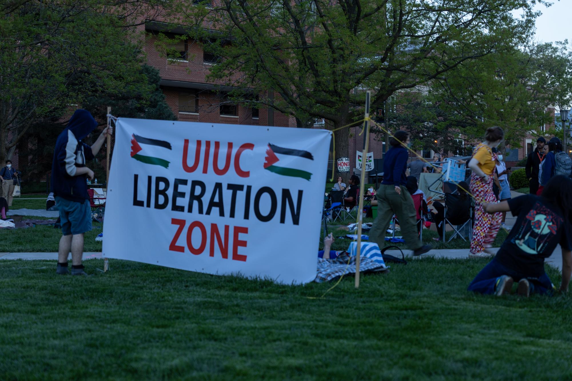 Demonstrators moving the “UIUC Liberation Zone” sign.