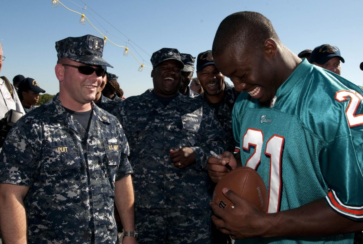 Miami+Dolphin+cornerback+Vontae+Davis+signs+a+football+for+Chief+Warrant+Officer+2nd+Mike+Puit+during+a+tour+of+the+guided-missile+destroyer+Pre-Commissioning+Unit+Jason+Dunham.