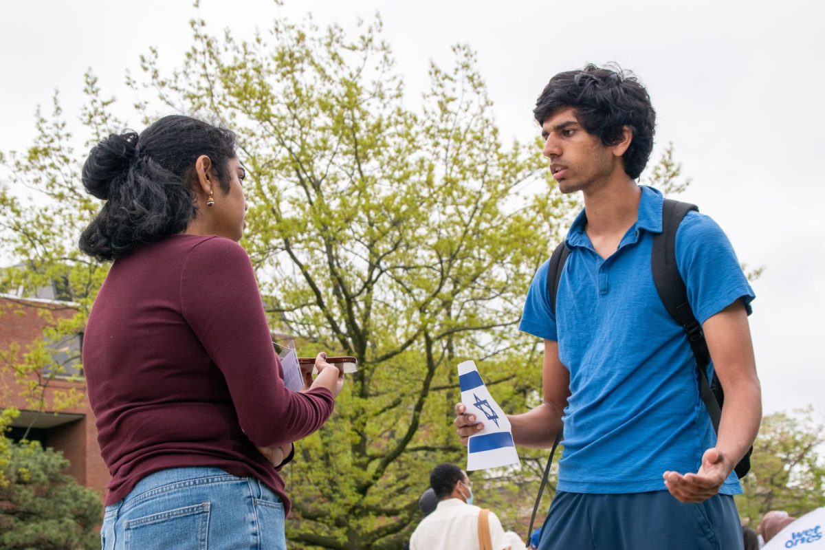 Staff photographer Anika Khandavalli interviews a student standing on the quad.
