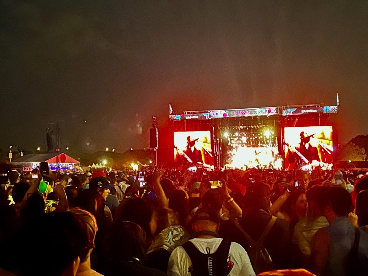 Crowd members raise their arms up during The Killers' headlining performance on Aug. 3. 