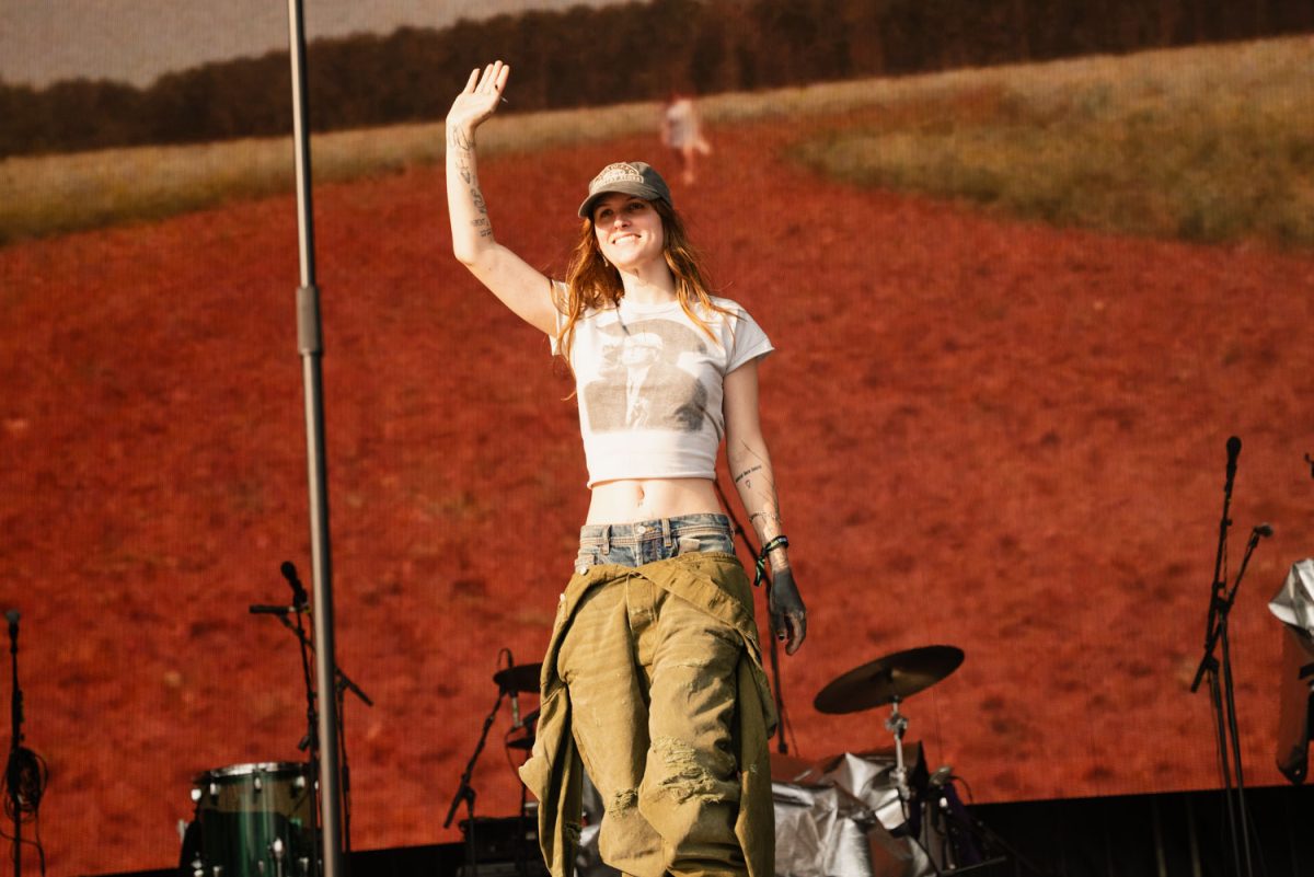 Ethel Cain waves to those attending her set as she approaches the mic to start her performance for day 3 of Lollapalooza.